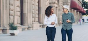 Two female business professional leaders engaged in a conversation and socialising.