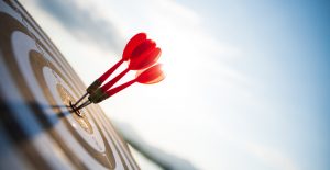 Close up shot of red darts arrows in the target centre. Business target, focus, goal success and winner concept.