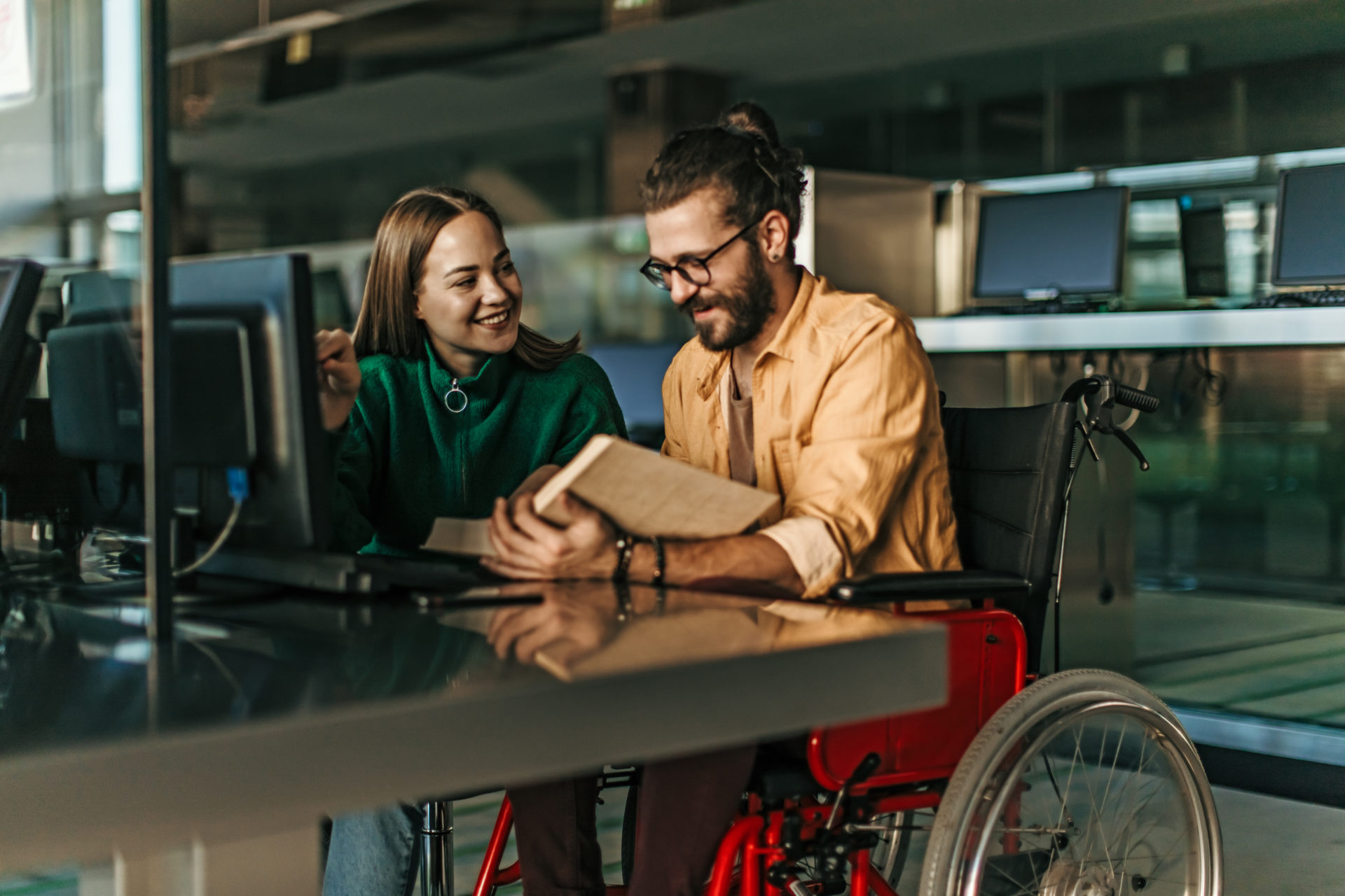 Student in wheelchair working with a classmate in library