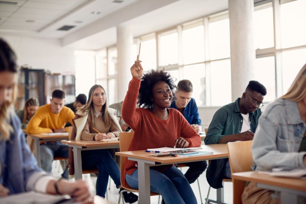 Happy African American student raising her hand to ask a question during lecture in the classroom. BGA Student of the Year Award