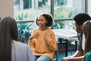 Upset female student talks about emotions during therapy session. World Mental Health Day 2022.