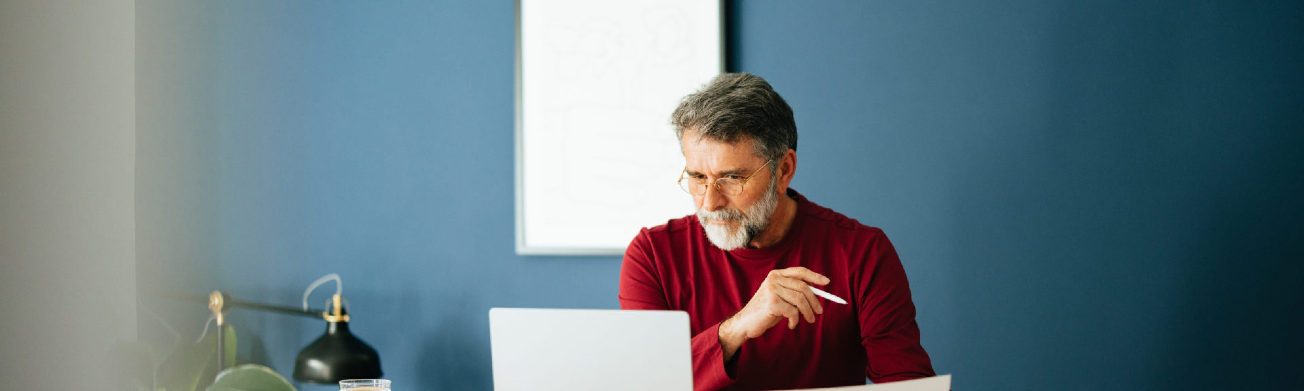 Senior Businessman Working In His Modern Office reading an annual report.