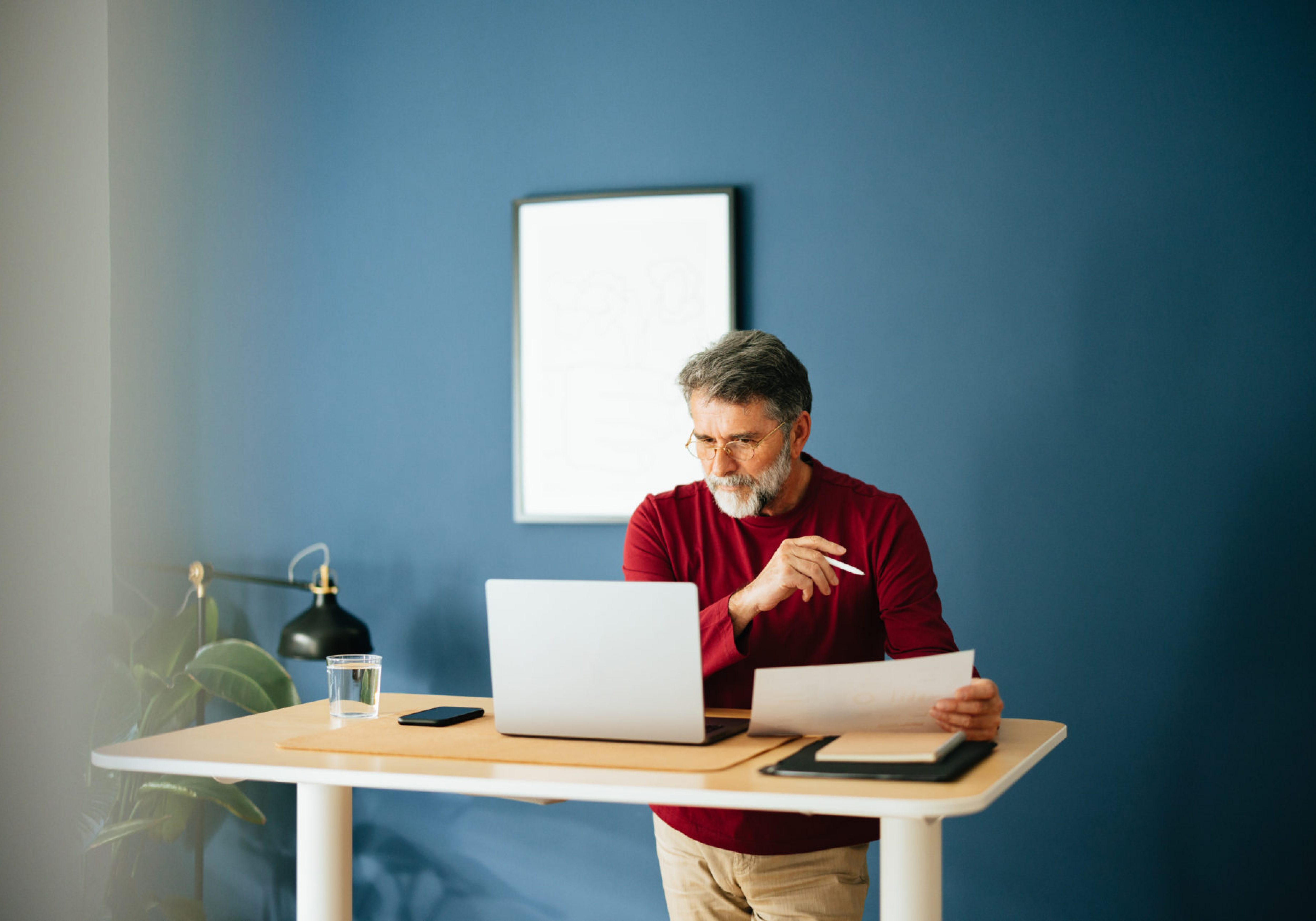 Senior Businessman Working In His Modern Office reading an annual report.