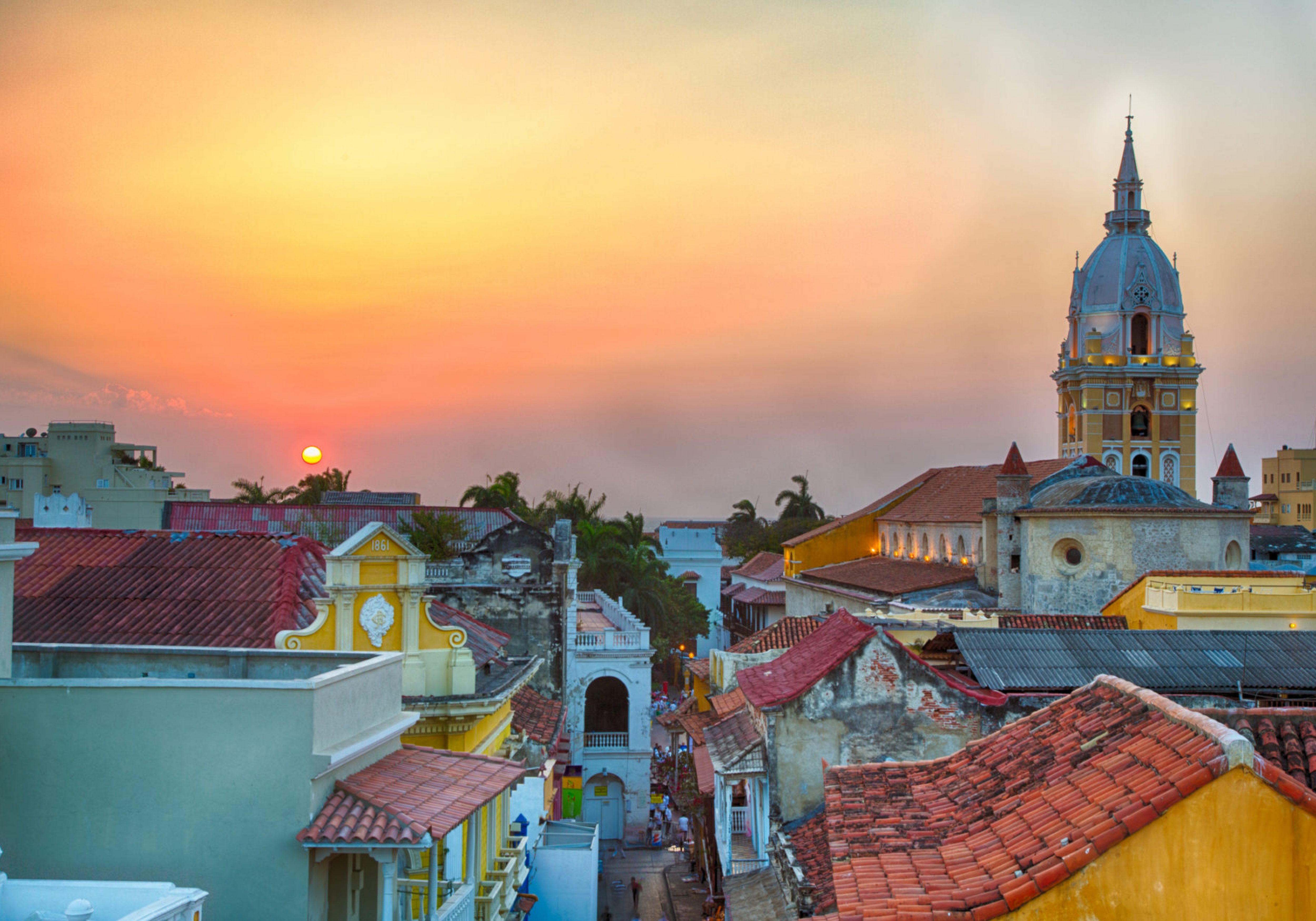 Latin American Capacity Building Workshop Four Image. View over the rooftops of the old city of Cartagena, Colombia, Latin America, during a vibrant sunset. The spire of Cartagena Cathedral stands tall and proud.