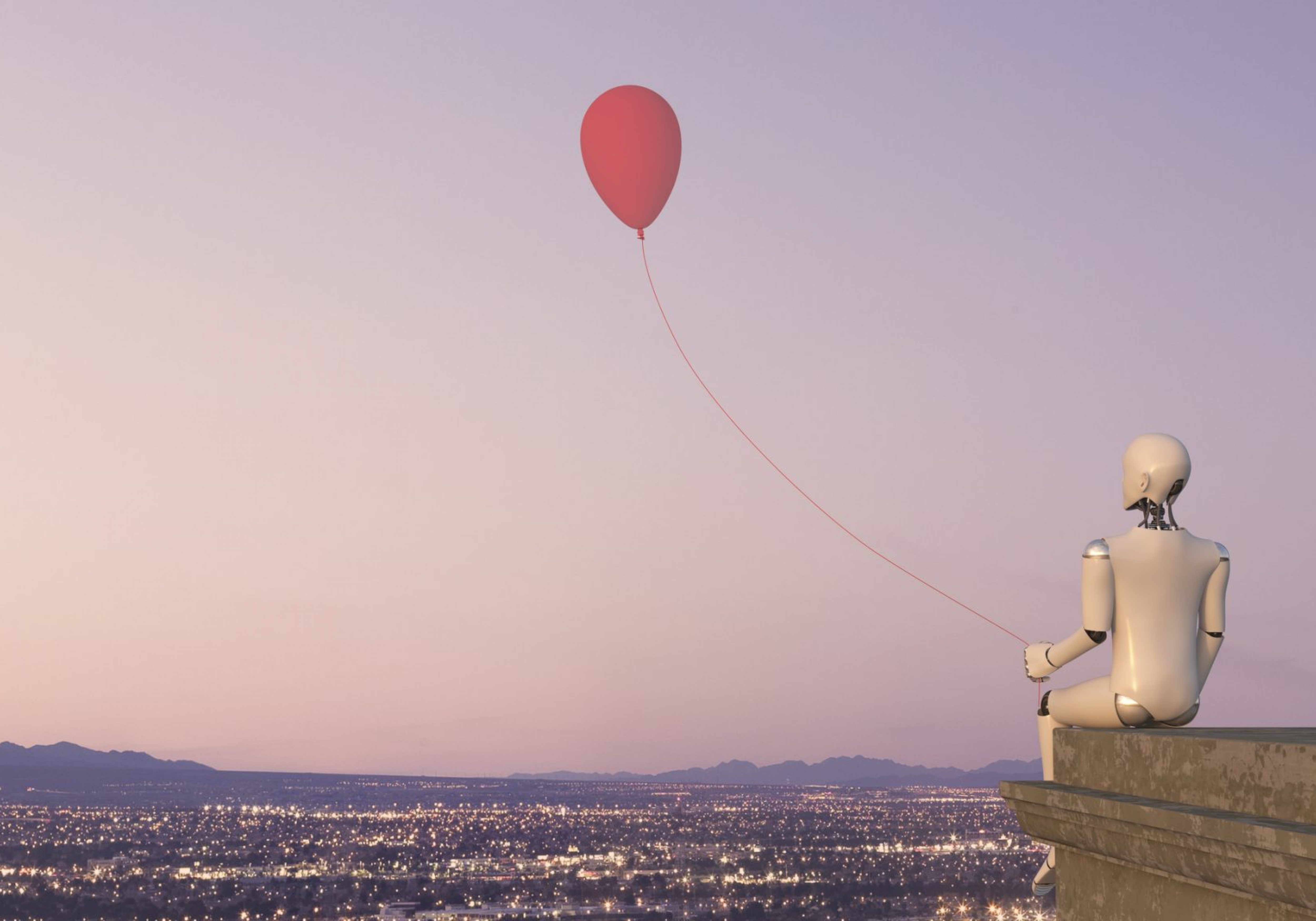 A white robot is sitting on the rooftop ledge of a building with the view of a city with lights, holding a red balloon. Business Impact article on Top tips to be a better daydreamer — and how it will help you.