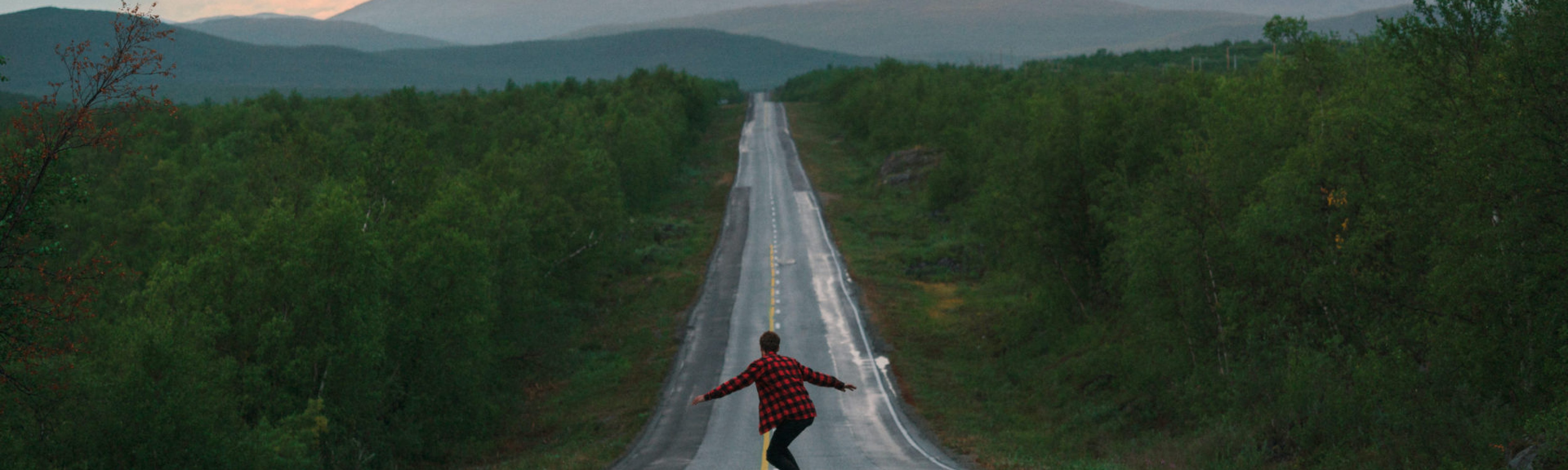 A student on a long journey skateboarding down a long road in Finland. Business Impact article image for How to upskill and perform to a high level quickly.